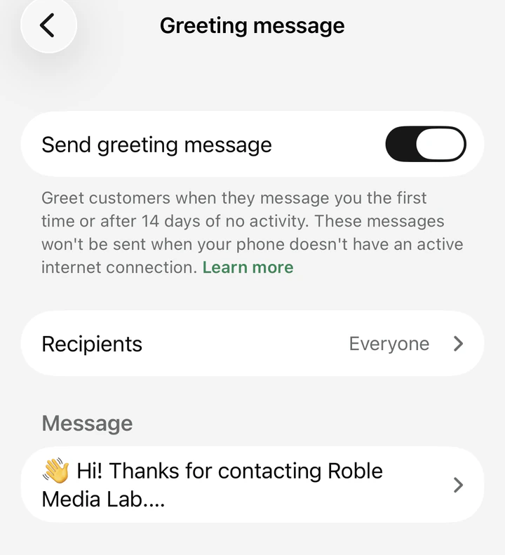 The Greeting message settings screen in WhatsApp Business, with the 'Send greeting message' toggle switched on, recipients set to Everyone, and a saved message